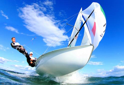 Due persone navigano su una barca a vela in mare aperto.
